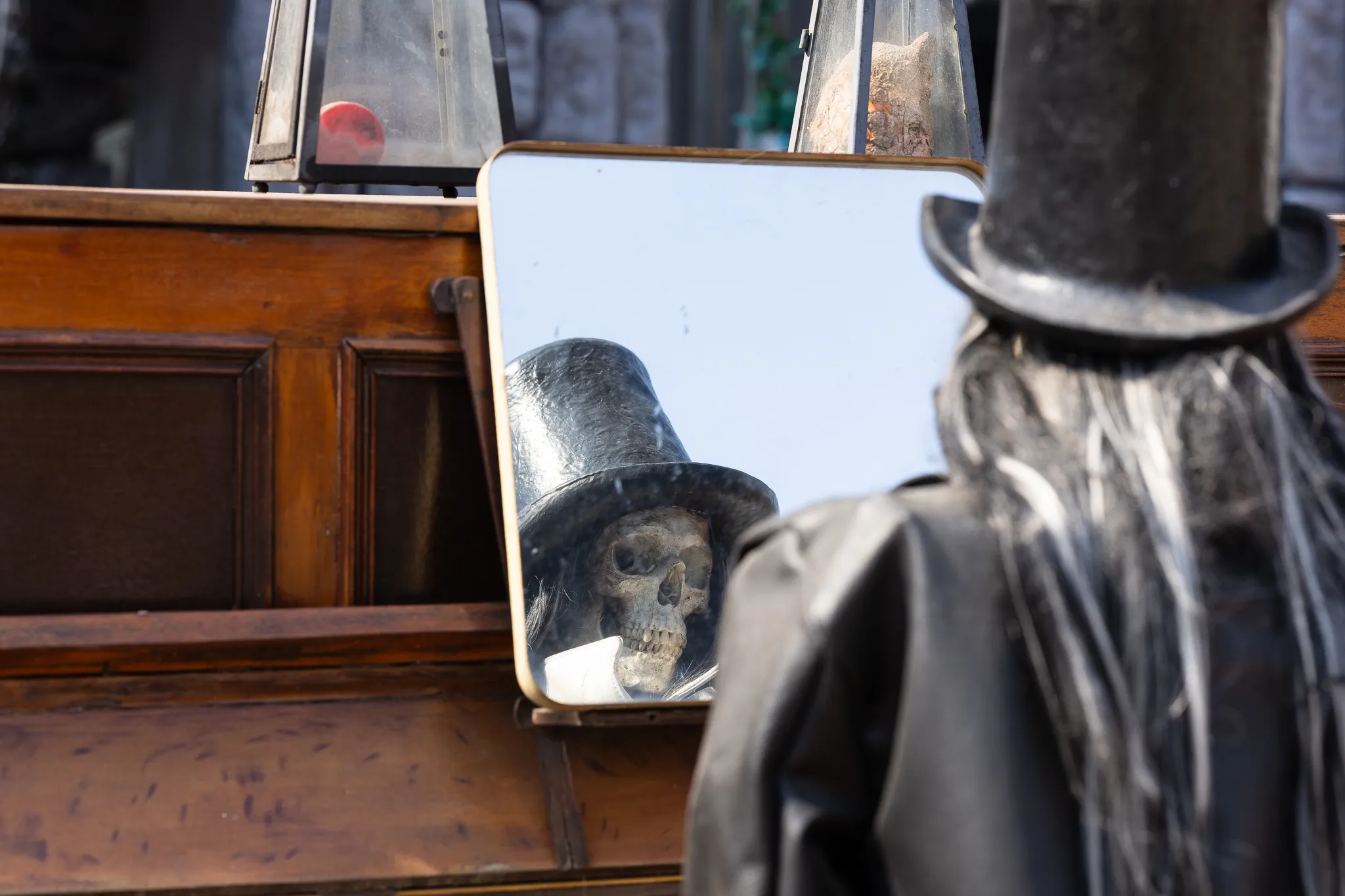 Ein Skelett mit schwarzem Zylinder sitzt am Piano; sein Gesicht ist in einem Spiegel zu sehen.